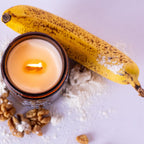 Candle in a glass jar with a banana and walnuts on a light background
