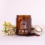 Brown jar with 'TBD Creatives' logo on a white background with decorative elements.